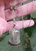 Glass cloche pendant with crimson mushrooms and moss on a copper filigree base