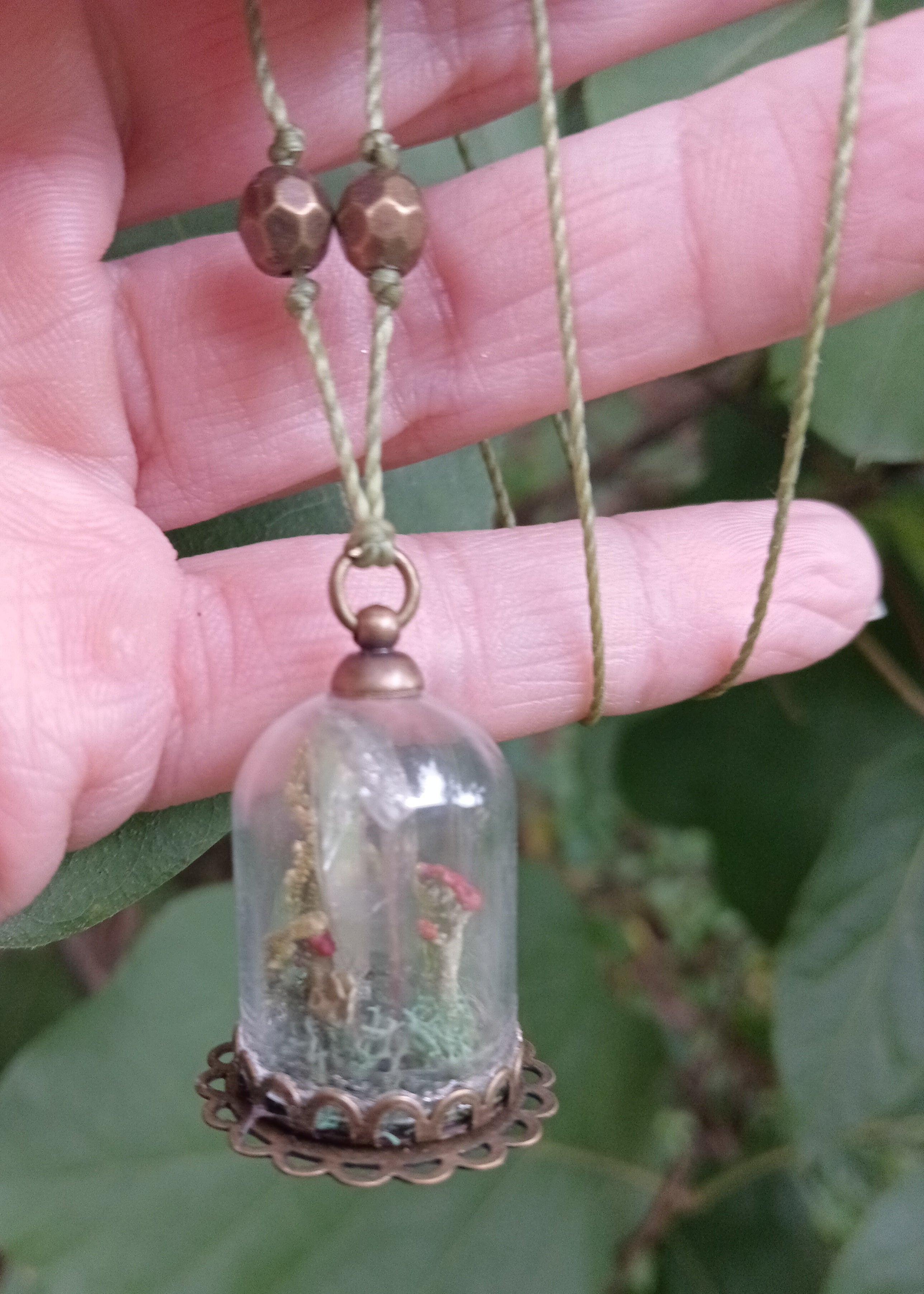 Glass cloche pendant with crimson mushrooms and moss on a copper filigree base