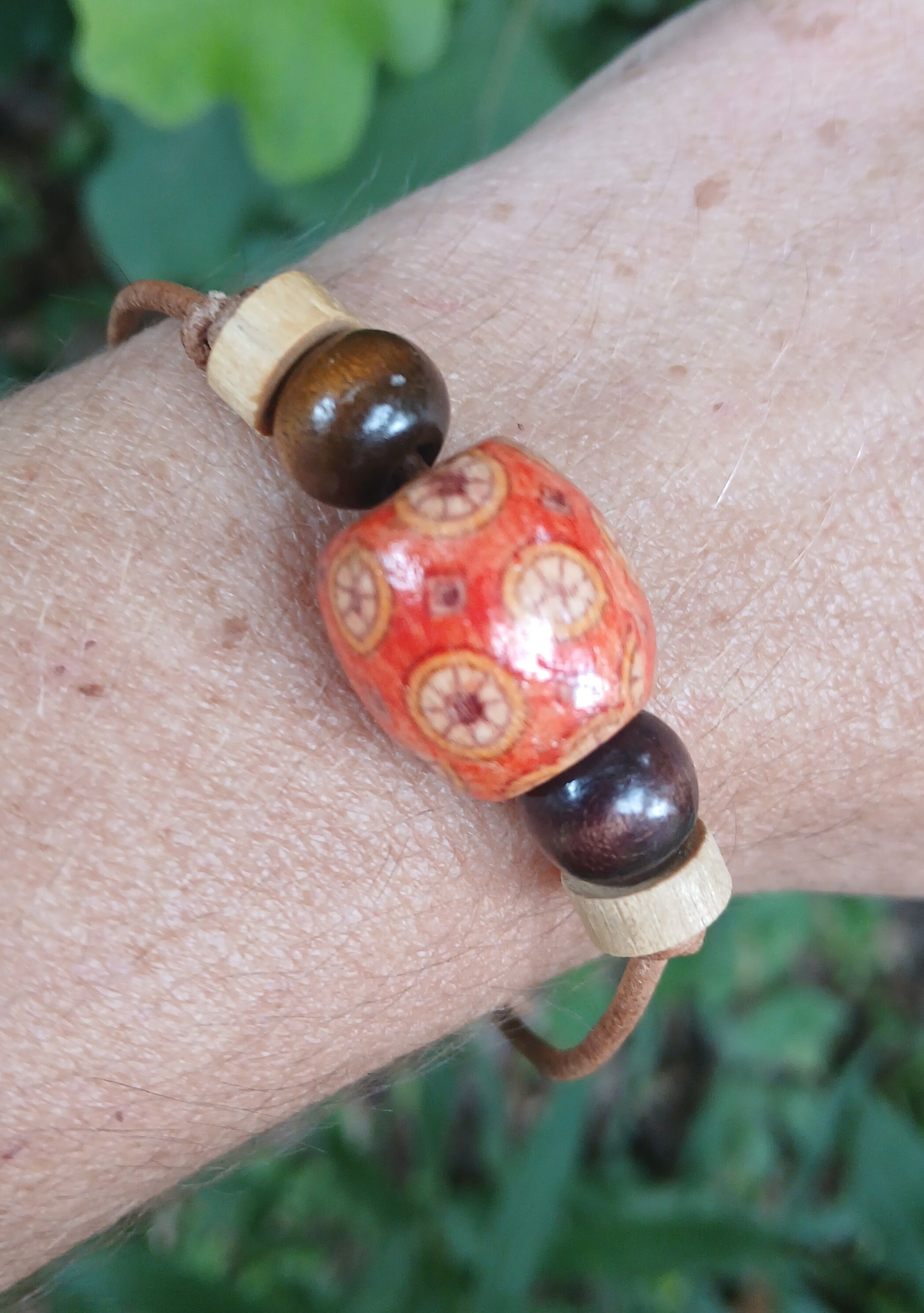 Leather bracelet with an orange hand-painted mandala bead and tiger's-eye accents